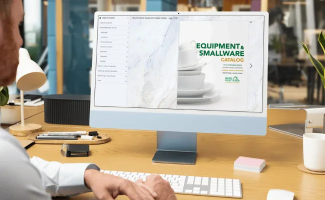 Professional foodservice equipment and smallware catalog displayed on desktop computer in modern office workspace environment.